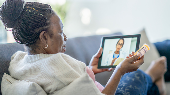 A patient speaks with their doctor on an iPad.