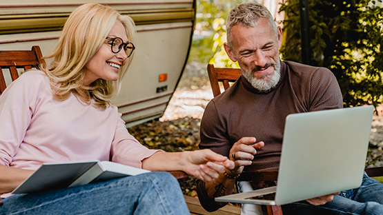 A man and woman look at a computer together.