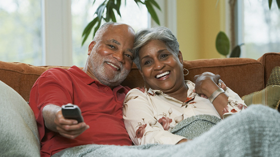 A husband and wife watch television together.